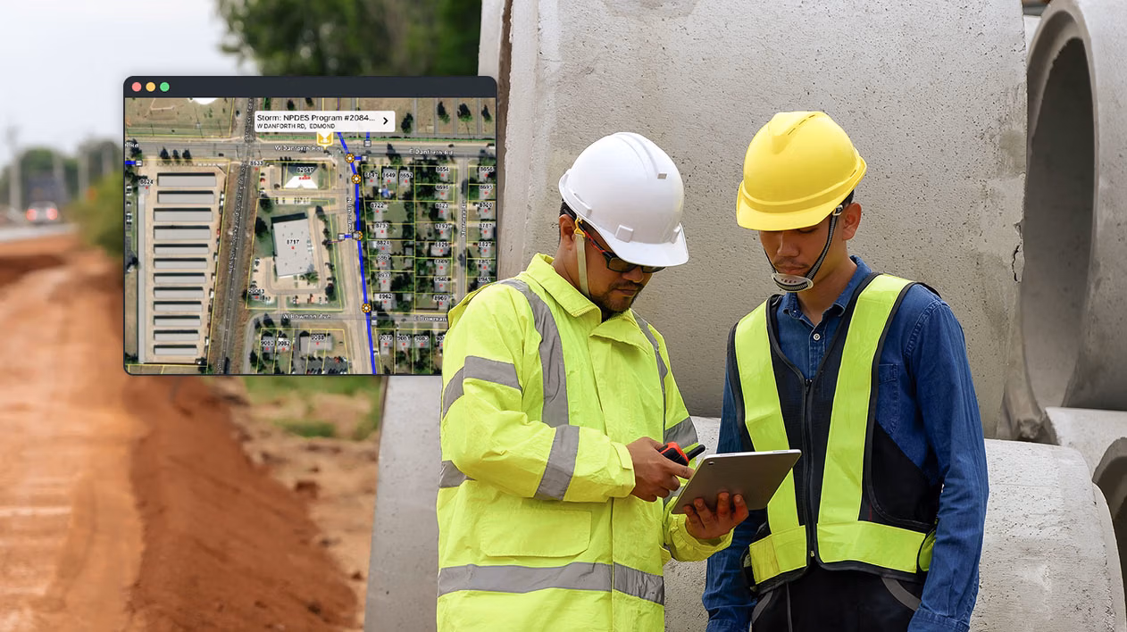 Construction workers using a tablet on-site with a map overlay showing stormwater program details.